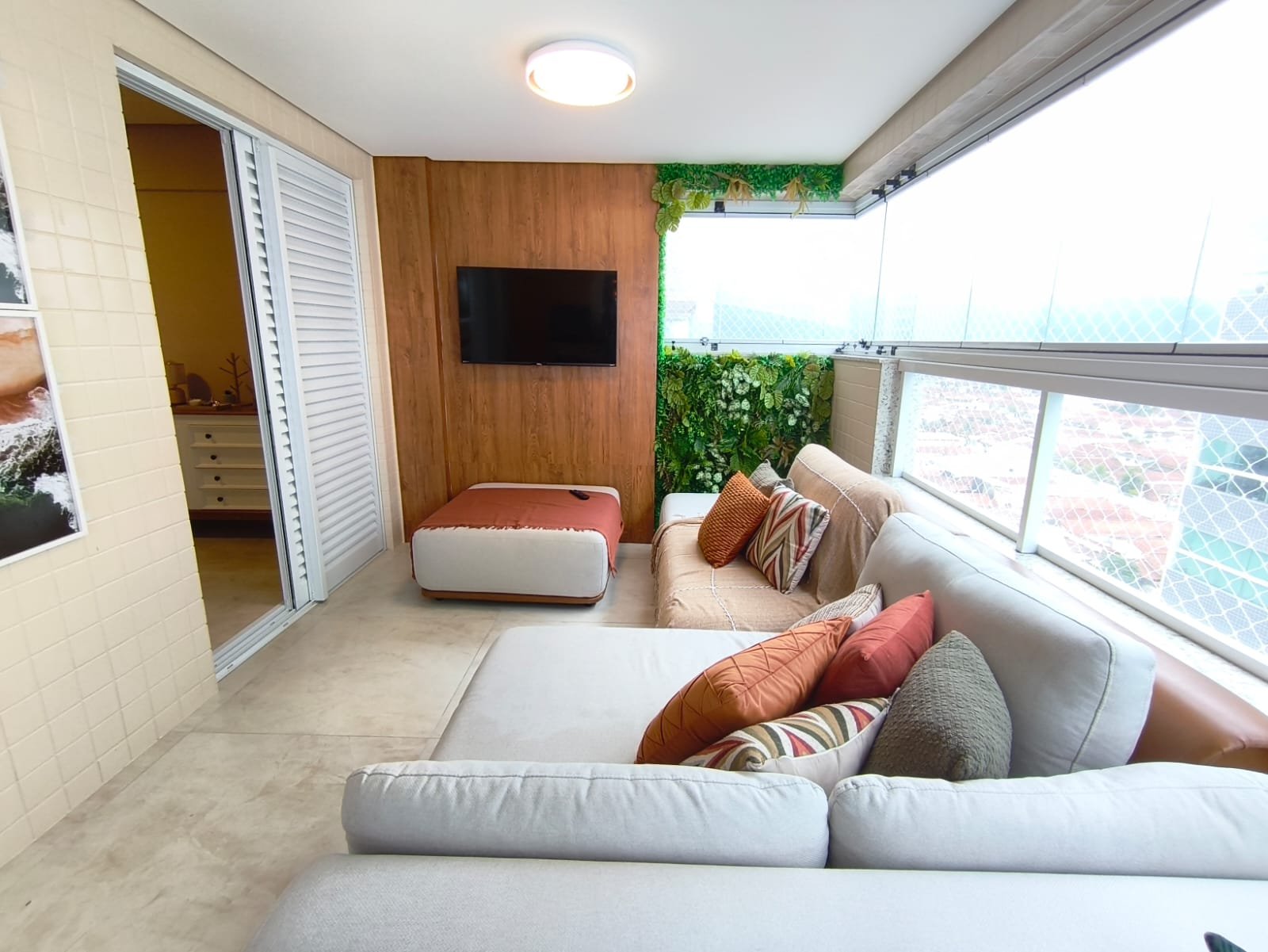 Varanda com TV e jardim vertical